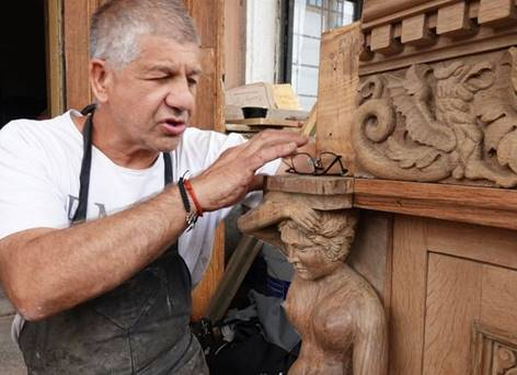 Rostás Árpád egy faragott, restaurált darabot vizsgál